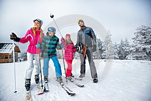 Winter time and skiing - family with ski and snowboard on ski ha